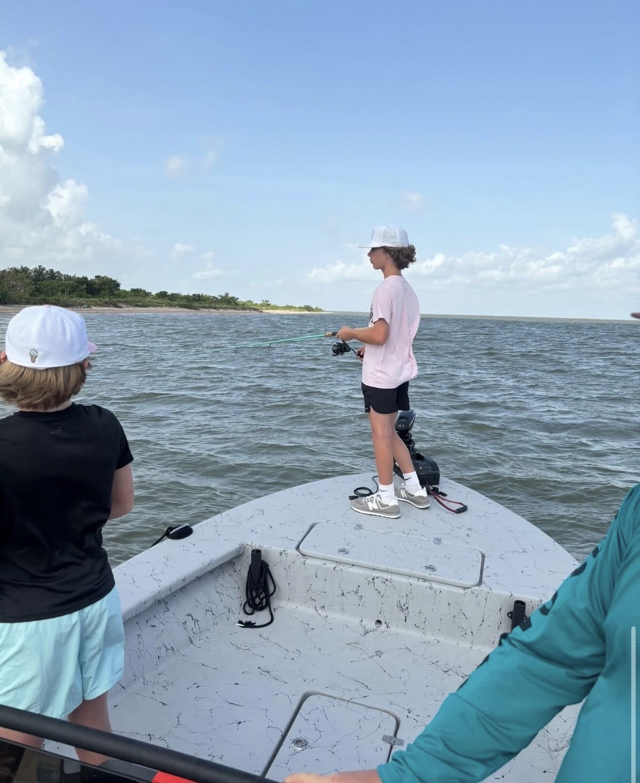 Family fishing trip in Galveston Bay — kids casting from the bow of the skiff