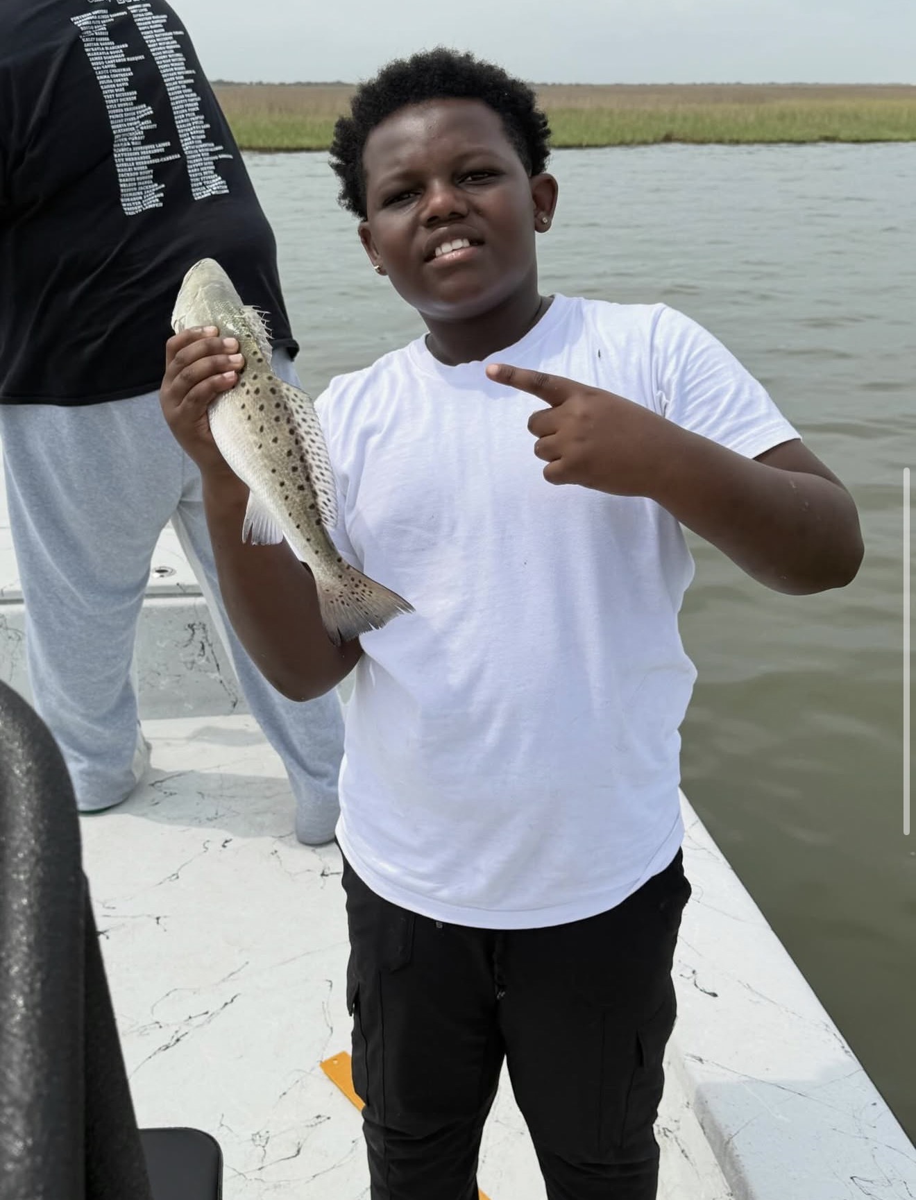 Youth angler catching a speckled trout on a Galveston family fishing trip